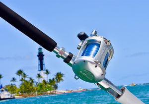 avet exw 50/2 lever drag big game reel on custom rod in front of lighthouse 